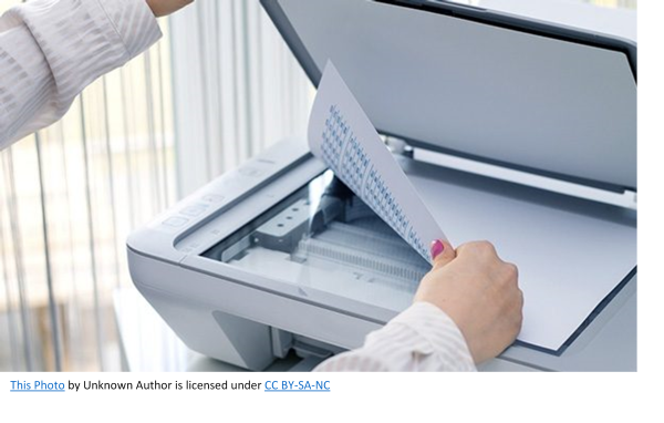 Image showing a persons hand laying a document face down on the scanner glass