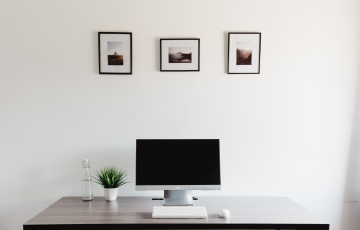 minimalist desk only a monitor, keyboard, mouse and small succulent all in white