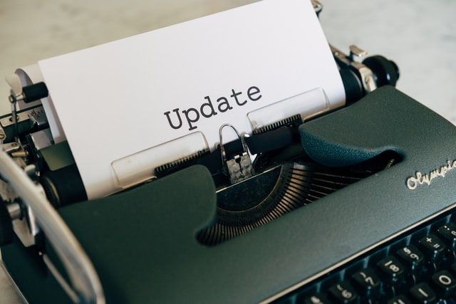 dark green typewriter holding a sheet of paper with the word Update printed on it