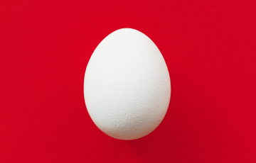 white egg on red background